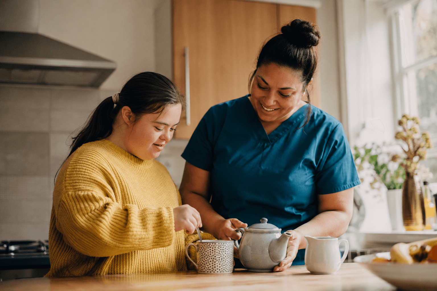 A woman and her support worker making tea together